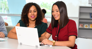 Dos estudiantes mujeres viendo una laptop