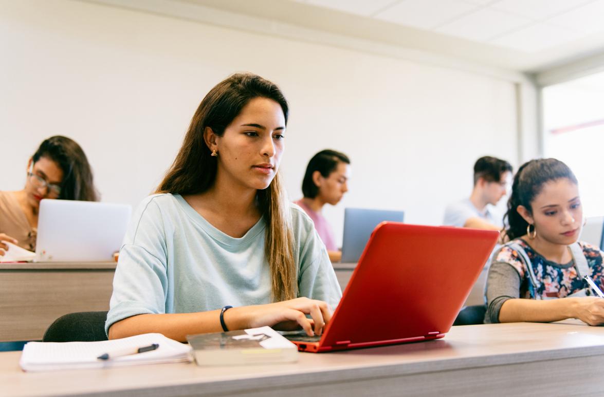 Foto de estudiante en un salon con una computadora