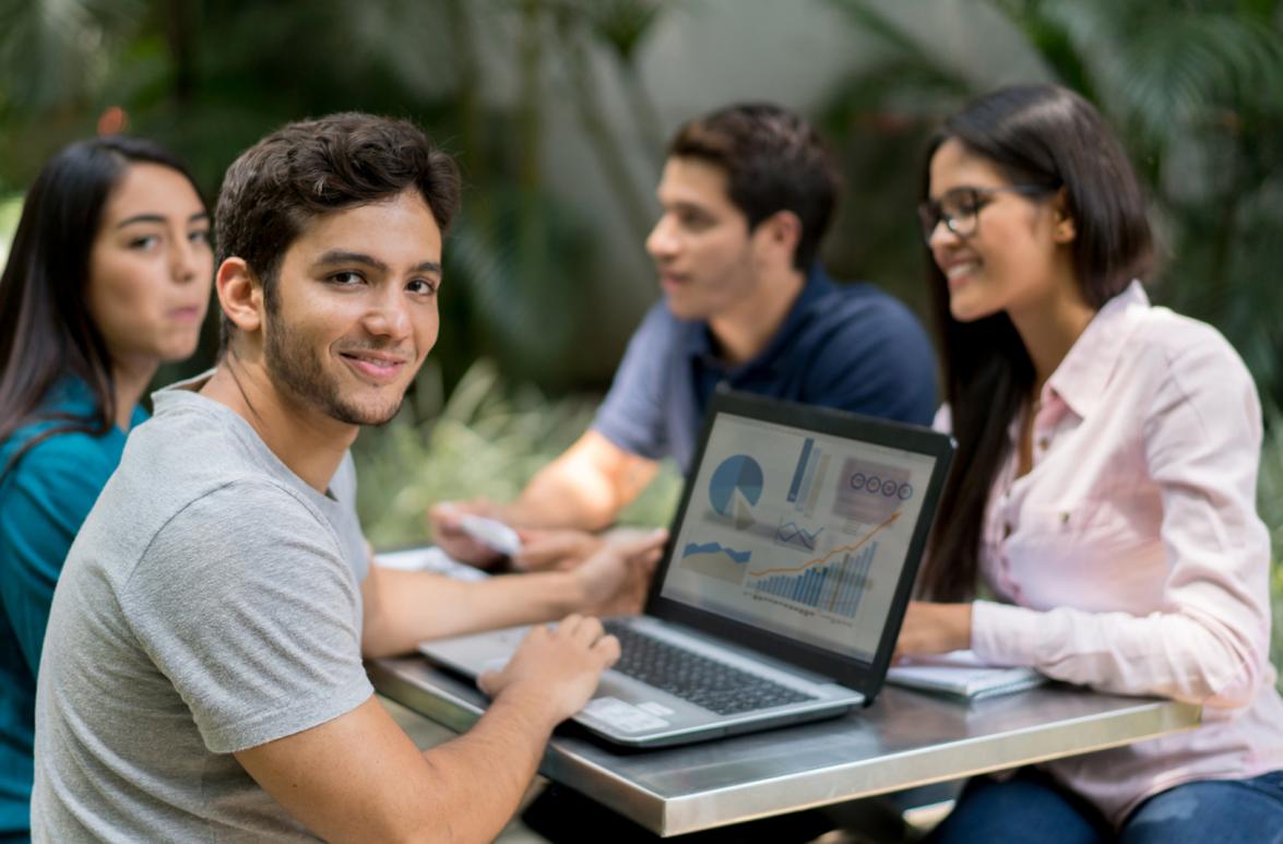 Grupo de estudiantes sentados en un banco en la universidad