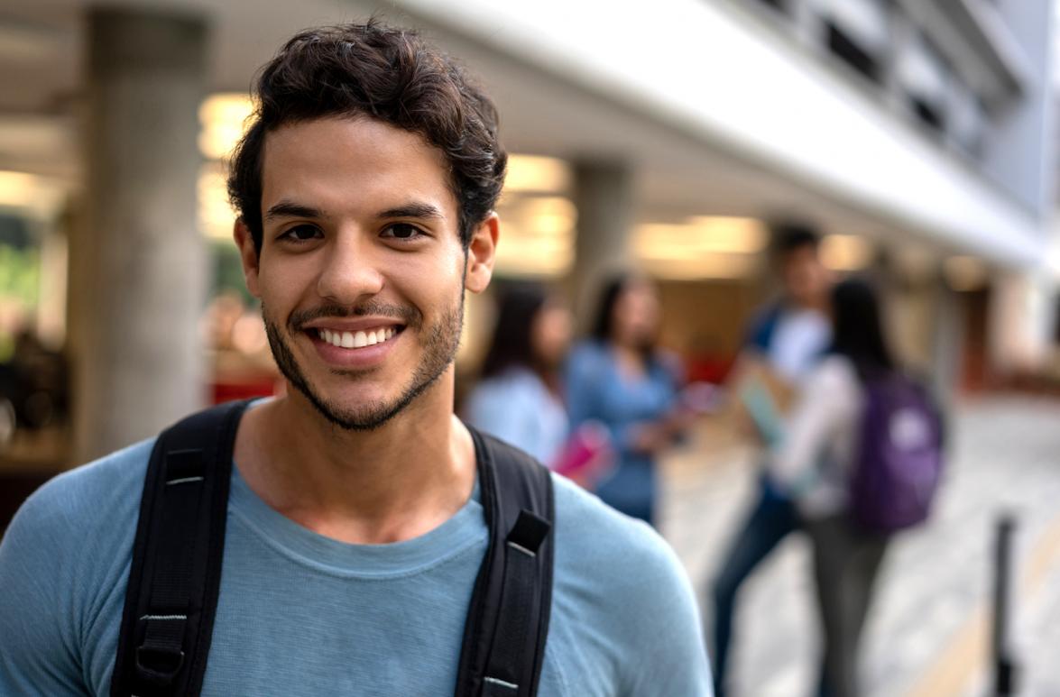 Foto de estudiante con mochila frente a la universidad