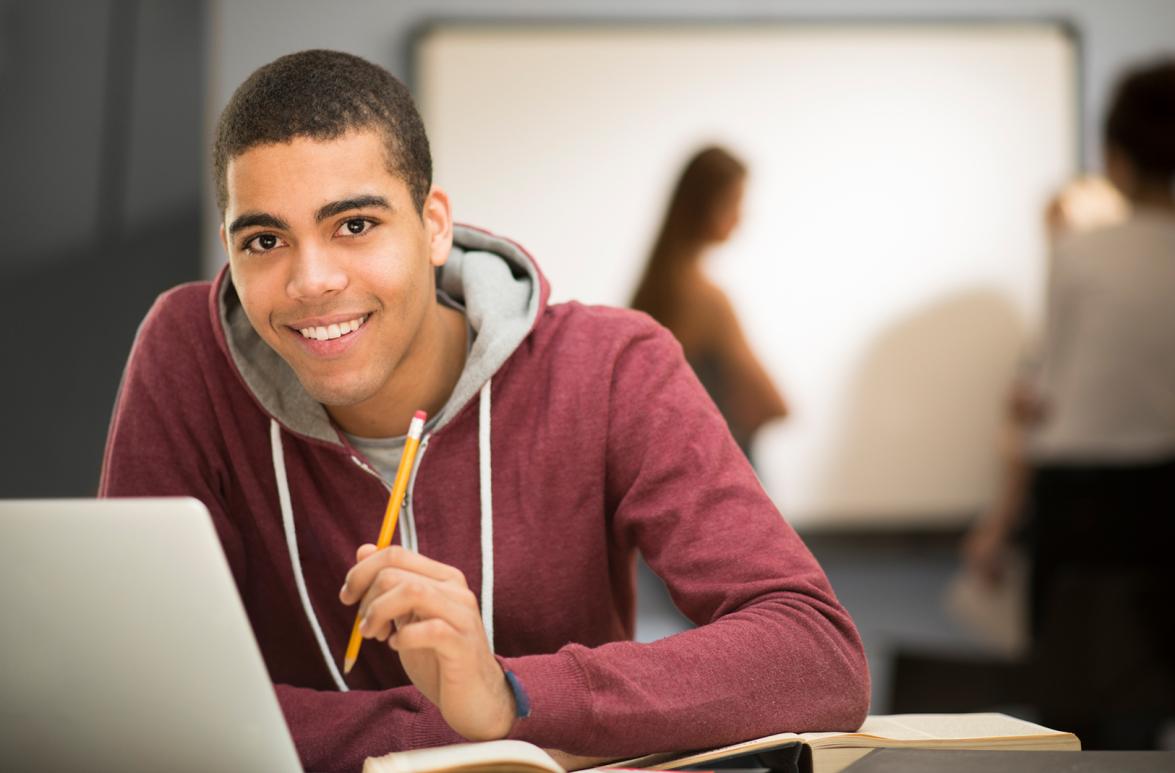 Estudiante sentado en escritorio con su laptop