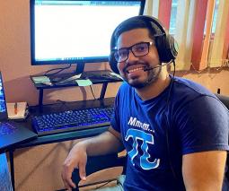 Foto delestudiante subgraduado Josué Martínez Martínez sentado frente a una computadora