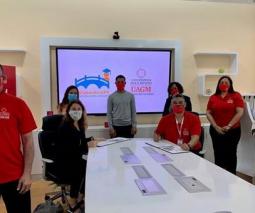 Foto de varios estudiantes y ejecutivos de UAGM parados alrededor de una mesa