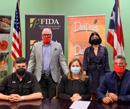Foto del grupo ejecutivo de la Universidad parados detras de una mesa