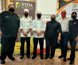 Varias personas vestidas de chef frente a un mostrador con comida