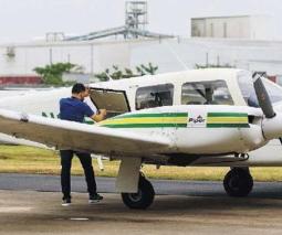 Avioneta blanca con dos rayas verdes y una amarilla