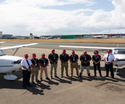grupo de estudiantes pilotos y dos avionetas