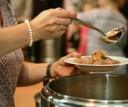 cocinera con olla en la mano repartiendo comida