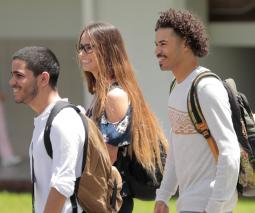 foto de 3 estudiantes caminando por el campus del recinto