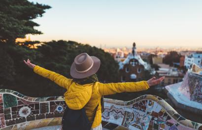 student with arms wide open in front of a tourist attraction